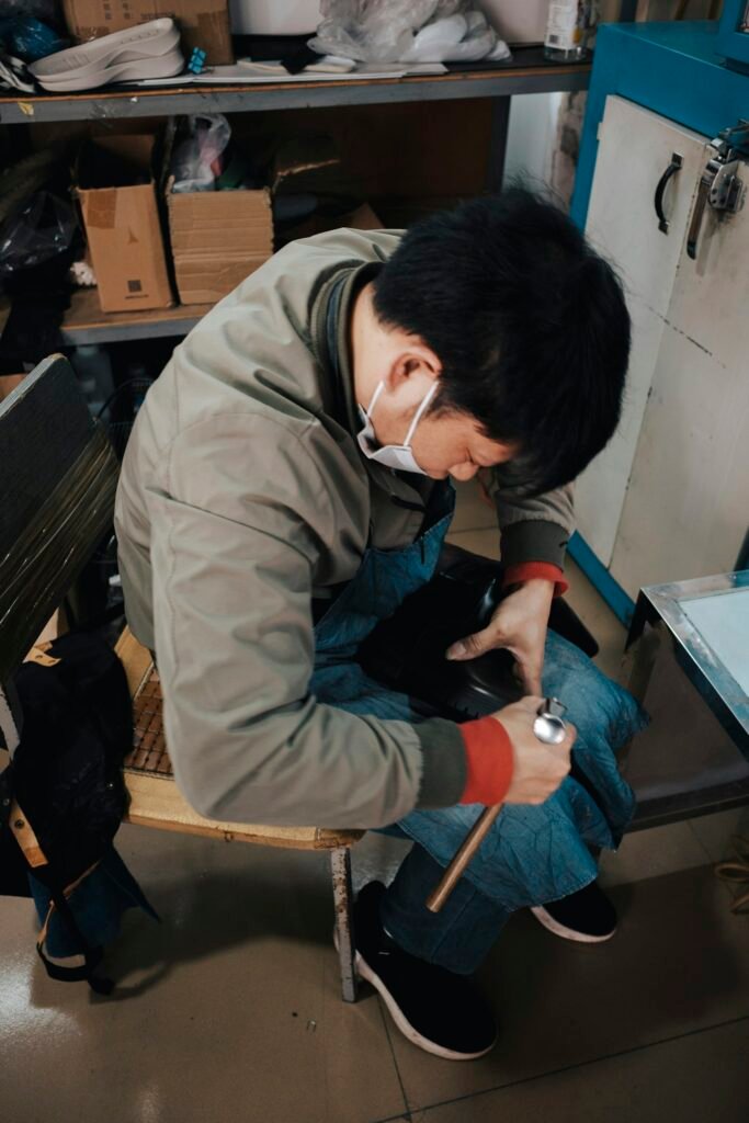 Worker finishing shoes in the workshop